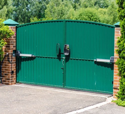 Casa con puerta verde de lamina tipo tablero de acero.