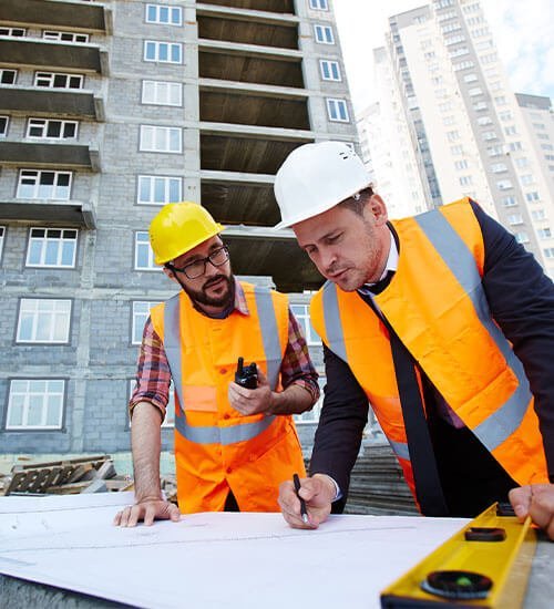 2 ingenieros con permiso para construir sosteniendo unos planos