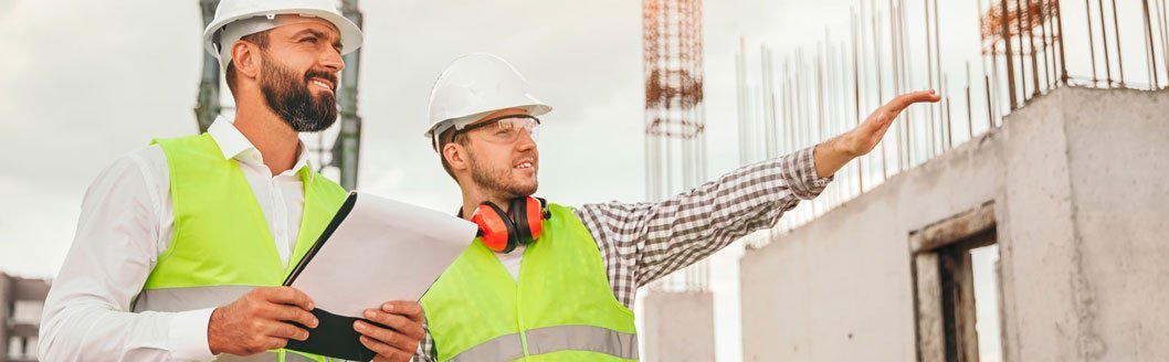 trabajadores de la obra con permiso para construir y muro detras levantado.