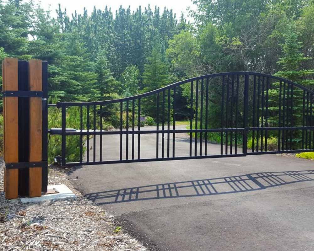 Portón de herrería con soportes dde madera colocado en la entrada de un rancho
