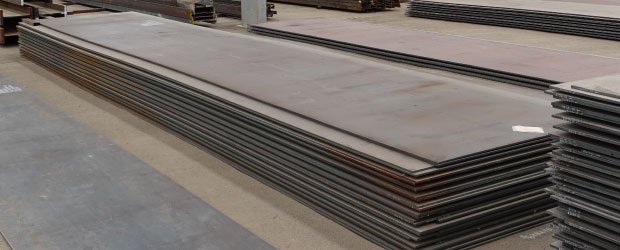 Varias placas de acero al carbón apiladas en bodega