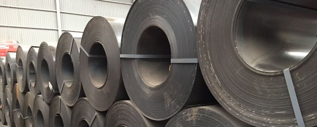 Conjunto de rollos de lámina negra apilada en bodega